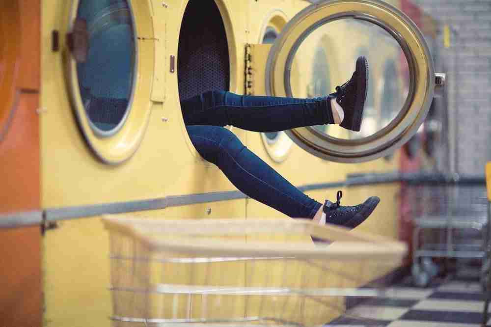 pieds sortant d'un lave linge dans un lavomatique